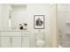 Clean bathroom with white cabinets, framed art, toilet and shower with curtain at 6503 Propel Run, New Port Richey, FL 34655