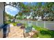 Backyard with seating around fire pit on patio with green lawn and partial fence at 701 Millifold Pl, Brandon, FL 33510
