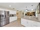 Open kitchen with stainless steel fridge, granite countertops, and breakfast bar overlooking the living area at 701 Millifold Pl, Brandon, FL 33510