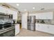 Bright and modern kitchen with stainless steel appliances, white cabinets, and bar seating at 701 Millifold Pl, Brandon, FL 33510