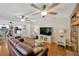 Spacious living room with wood floors and multiple ceiling fans leading to kitchen and dining area at 701 Millifold Pl, Brandon, FL 33510