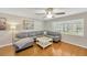 Well-lit living room with hardwood floors, a gray sectional, and plantation shutters at 701 Millifold Pl, Brandon, FL 33510