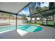 Inviting in-ground pool inside screened enclosure, with dining and lounging area and lush backyard at 701 Millifold Pl, Brandon, FL 33510