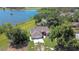 An aerial view of a charming home with a large three-car garage, lush landscaping, and beautiful views of the nearby lake at 709 Sportsman Park Dr, Seffner, FL 33584