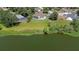 Aerial view of a home with a pool overlooking a lake, surrounded by lush greenery in a serene setting at 709 Sportsman Park Dr, Seffner, FL 33584