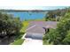 Stunning aerial view of a well-maintained home with a three-car garage and beautiful lake backdrop at 709 Sportsman Park Dr, Seffner, FL 33584