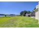 Spacious backyard with lush green lawn, mature trees, and serene lake views, offering a private outdoor retreat at 709 Sportsman Park Dr, Seffner, FL 33584