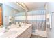 Neutral bathroom featuring double sinks, bathtub with shower, and tiled floors provides ample space at 709 Sportsman Park Dr, Seffner, FL 33584