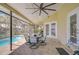 Inviting covered patio with a dining set and ceiling fan, overlooking a beautiful swimming pool at 709 Sportsman Park Dr, Seffner, FL 33584