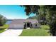 Charming single-Gathering home with a well-manicured lawn, attached three-car garage, and lovely landscaping at 709 Sportsman Park Dr, Seffner, FL 33584