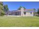 Home exterior featuring a screened-in patio, chimney, and well-maintained lawn, ideal for outdoor living at 709 Sportsman Park Dr, Seffner, FL 33584