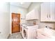 Well-equipped laundry room offers a washer and dryer, utility sink, and ample storage for convenience at 709 Sportsman Park Dr, Seffner, FL 33584