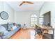 A bright office space featuring hardwood floors, a futon, and a large window for natural light at 709 Sportsman Park Dr, Seffner, FL 33584