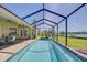 Sparkling pool with a screened enclosure, beautiful views of the lake, and a covered patio with dining set at 709 Sportsman Park Dr, Seffner, FL 33584