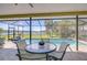 Relaxing screened lanai with a pool, table and chairs, providing a serene spot with a lake view at 709 Sportsman Park Dr, Seffner, FL 33584