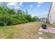 Large backyard with grass, patio area with fire pit, and screened-in pool enclosure at 7235 Sharpsburg Blvd, New Port Richey, FL 34653