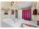 Bathroom with vanity and mirror and red plaid shower curtain and towels at 7235 Sharpsburg Blvd, New Port Richey, FL 34653