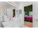 Bathroom featuring double sinks, vanity lights, and view into the adjacent main bedroom at 7235 Sharpsburg Blvd, New Port Richey, FL 34653