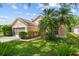 Home with mature landscaping, including palm trees, and a well-manicured lawn at 7235 Sharpsburg Blvd, New Port Richey, FL 34653