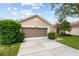 Attractive house with well-kept lawn, green shrubbery, and a two-car garage with screened doors at 7235 Sharpsburg Blvd, New Port Richey, FL 34653