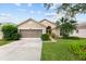 Charming home featuring a well-maintained lawn, mature landscaping, and a two-car garage with screened doors at 7235 Sharpsburg Blvd, New Port Richey, FL 34653