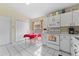Eat-in kitchen featuring white cabinets, appliances, tile floors, and a cozy dining area, creating a warm, inviting space at 7235 Sharpsburg Blvd, New Port Richey, FL 34653
