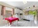 Charming eat-in kitchen featuring white cabinetry, breakfast bar, tile floors, and natural light from the surrounding windows at 7235 Sharpsburg Blvd, New Port Richey, FL 34653