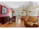 Bright living room with hardwood floors, neutral sofa, brick accent wall, and a ceiling fan at 7235 Sharpsburg Blvd, New Port Richey, FL 34653
