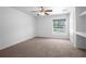 Bright carpeted bedroom with a ceiling fan and a window overlooking the lawn at 7285 Nightwalker Rd, Weeki Wachee, FL 34613