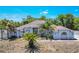 Spacious home featuring elegant columns, arched windows, and a lush garden with mature palms in the front yard at 7285 Nightwalker Rd, Weeki Wachee, FL 34613
