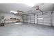 Spacious garage featuring overhead lighting and a work bench area, offering ample storage at 7285 Nightwalker Rd, Weeki Wachee, FL 34613