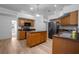 Well-lit kitchen with wood cabinets, center island, and stainless steel appliances at 7285 Nightwalker Rd, Weeki Wachee, FL 34613