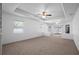 Carpeted living room featuring a ceiling fan and multiple windows for natural light at 7285 Nightwalker Rd, Weeki Wachee, FL 34613