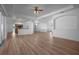 Inviting living room with wood flooring, a ceiling fan, and access to the kitchen and pool area at 7285 Nightwalker Rd, Weeki Wachee, FL 34613