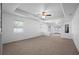 Carpeted living room featuring a ceiling fan and multiple windows for natural light at 7285 Nightwalker Rd, Weeki Wachee, FL 34613