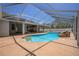 Screened-in pool with rock features and a built-in bar area for entertaining, offering a resort-like experience at home at 7285 Nightwalker Rd, Weeki Wachee, FL 34613