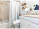 Cozy bathroom featuring shower over tub, toilet, vanity and open shelves at 7903 Heather Ct, Tampa, FL 33634