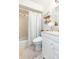 Cozy bathroom featuring shower over tub, toilet, vanity and open shelves at 7903 Heather Ct, Tampa, FL 33634