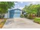 A well-maintained two-car garage with an adjacent concrete driveway, framed by lush greenery and a white picket fence at 7903 Heather Ct, Tampa, FL 33634