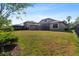 Spacious backyard with a healthy lawn, partial fencing, and an extended screened-in lanai area at 7911 Hampton Lake Dr, Tampa, FL 33647