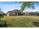 Expansive backyard featuring healthy green grass, partially enclosed by a fence, and a screened patio at 7911 Hampton Lake Dr, Tampa, FL 33647