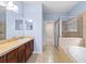 Bathroom featuring double sinks, glass shower, bathtub and tile flooring at 7911 Hampton Lake Dr, Tampa, FL 33647