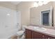 Bright bathroom with a single sink vanity, toilet, and shower-tub combo with white tile surround at 7911 Hampton Lake Dr, Tampa, FL 33647