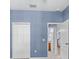 Bedroom featuring soft blue walls, closet, and white door leading to bathroom and staircase at 7911 Hampton Lake Dr, Tampa, FL 33647
