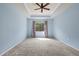 Bright bedroom with ceiling fan, carpeted floors, and a window letting in natural light at 7911 Hampton Lake Dr, Tampa, FL 33647