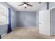 This bright bedroom includes neutral carpeting, a ceiling fan, and a large window at 7911 Hampton Lake Dr, Tampa, FL 33647