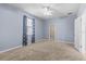 Spacious bedroom with ceiling fan, plush carpet, and ample natural light at 7911 Hampton Lake Dr, Tampa, FL 33647