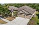 Spacious home featuring a three-car garage, well-manicured lawn, and a neutral color palette at 7911 Hampton Lake Dr, Tampa, FL 33647