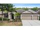Beautiful single-Gathering home featuring a three-car garage, neat landscaping, and welcoming architectural details at 7911 Hampton Lake Dr, Tampa, FL 33647