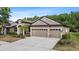 Inviting home with a three-car garage, lush landscaping, and a well-kept front yard, perfect for families at 7911 Hampton Lake Dr, Tampa, FL 33647
